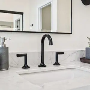 Master bath sink with black matte fixtures and marble quartz in Camarillo by JRP Design and Remodel