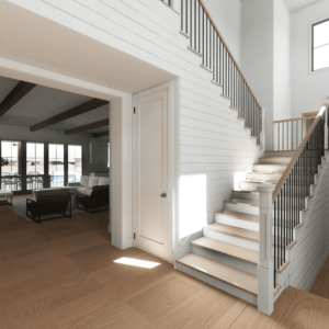 A modern farmhouse interior featuring an open living area, well-lit with natural light, hardwood floors, and a staircase with white railings. Large windows enhance the welcoming atmosphere.