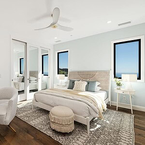 A modern bedroom with a bed, white desk and chair, pendant light, mirrored closet doors, and large windows offering a stunning Carrita Seaview. The room has light-colored walls, wooden flooring, and is decorated in neutral tones.