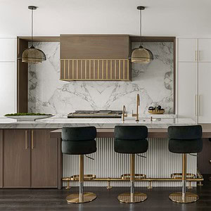 Modern kitchen with sophisticated glamour, featuring a large island adorned with black and gold bar stools, white marble countertops, and a marble backsplash with wood accents. Pendant lights hang above the island while white cabinets line the wall.