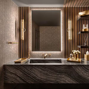 A modern bathroom exudes sophisticated glamour with a large, illuminated mirror, a marble sink countertop, wall-mounted shelves adorned with decor, and elegant gold fixtures. The walls are textured with a metallic finish.