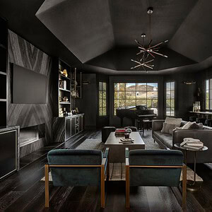 A modern living room with dark gray walls, high ceilings, a large TV, and various furnishings exudes sophisticated glamour. The room features a blend of wood and metal accents, alongside a piano and vibrant neon artwork on the wall.