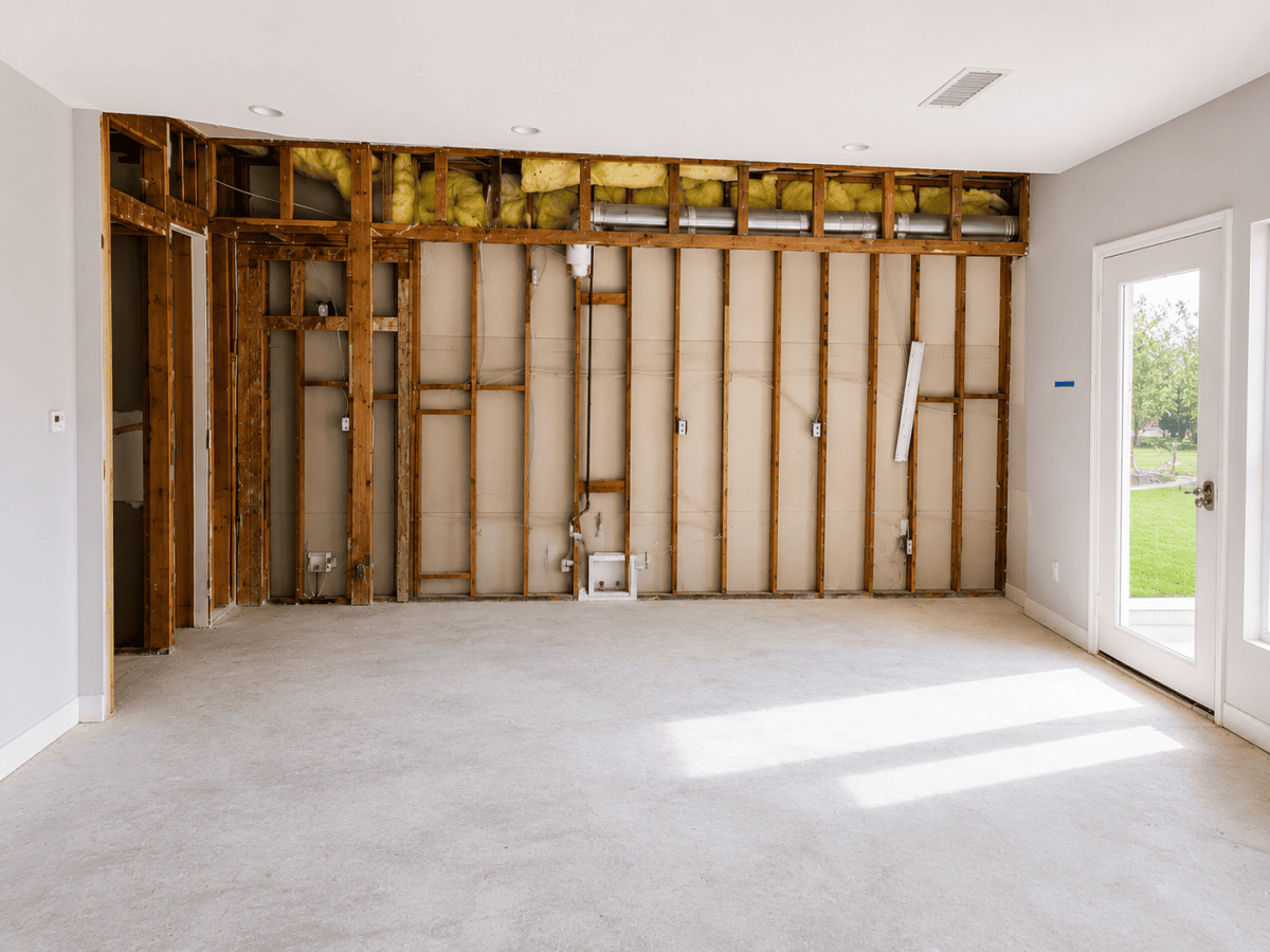 Unfinished kitchen with exposed wall framing and insulation.