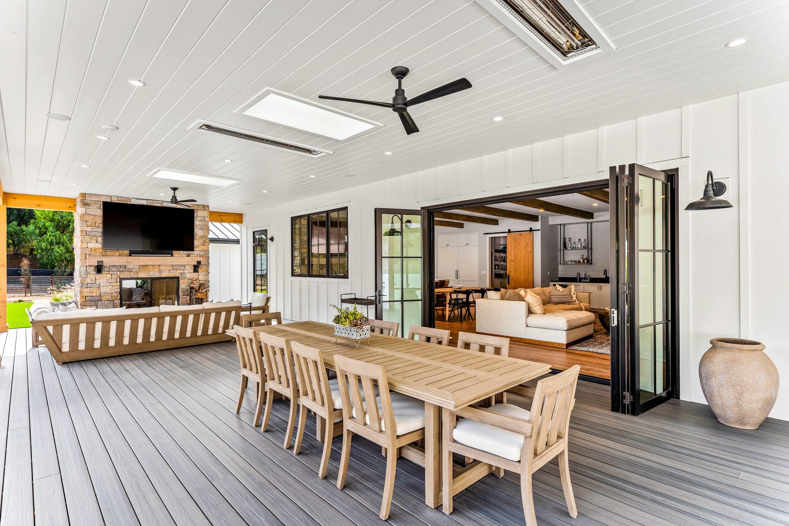 Spacious outdoor dining area with fireplace and sliding doors.
