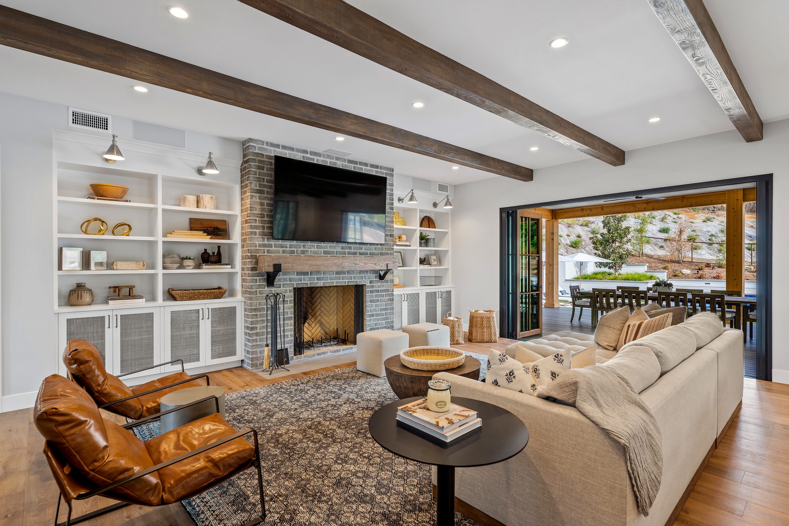 Spacious living room with brick fireplace, built-in shelves, and sliding glass doors.