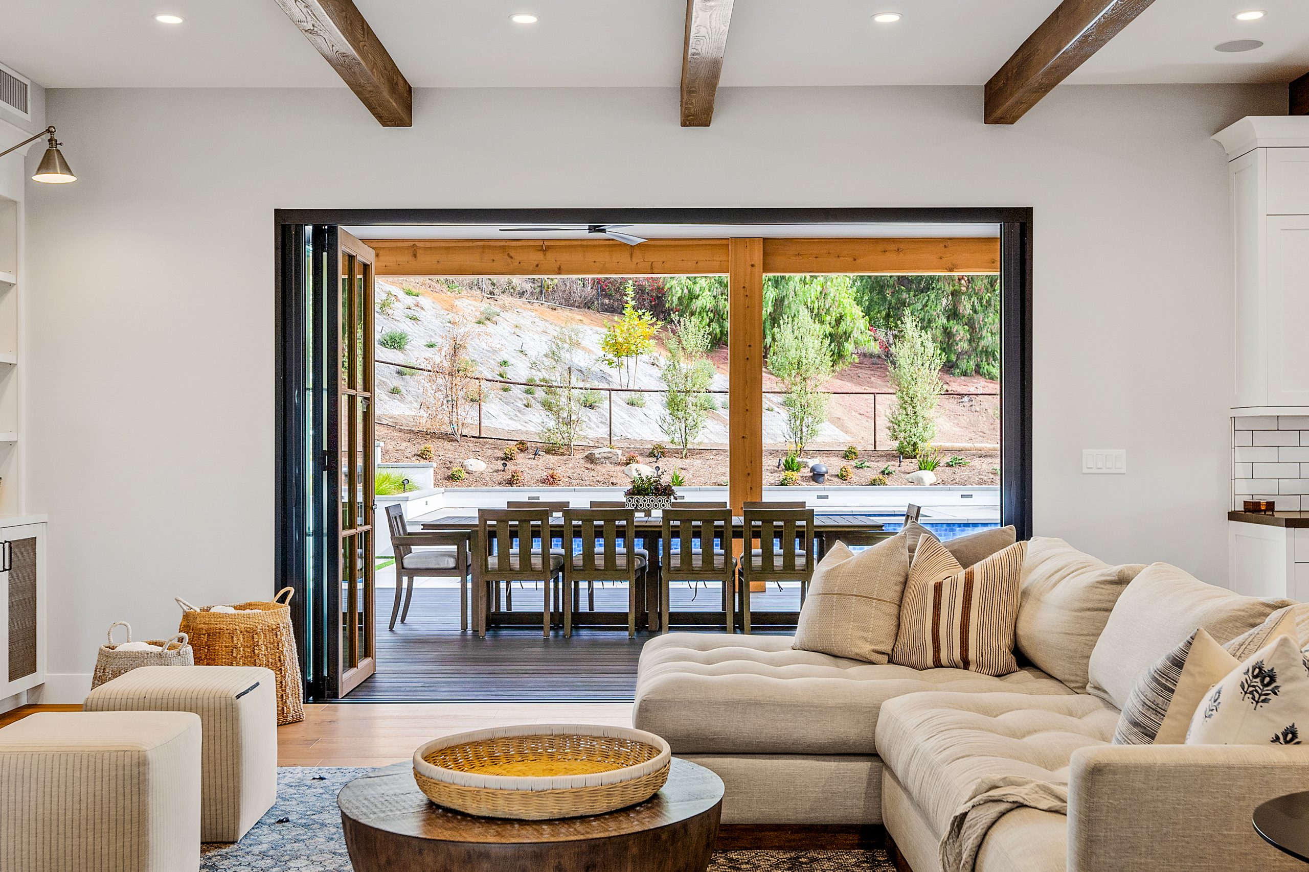 Bright living room with large sliding doors opening to outdoor patio and scenic view.